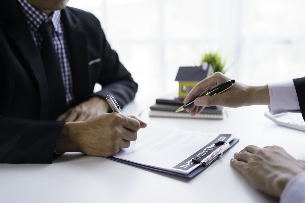 The real estate agent is explaining the home design to interested clients and signing an office sales contract.